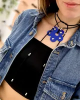 Gargantilla choker con doble tira de cuero sintético negro y dije de flor acrílica azul con apliques de strass.