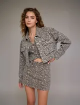 Campera de jean estampada con animal print de leopardo en tonos beige y gris, marca Hidden. Tiene cuello solapa, abertura frontal con botones metálicos, bolsillos delanteros y ruedo elastizado en la espalda.