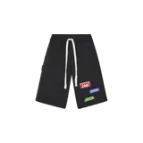 Short negro de felpa con cordón ajustable blanco en la cintura, bolsillos laterales y varios parches decorativos estampados en la pierna izquierda.