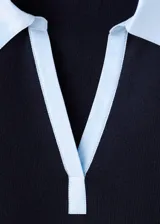Jersey de punto grueso negro con mangas largas y cuello camisero superpuesto en color celeste.