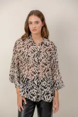 Camisa de seda natural con estampado animal print, de corte holgado, cuello camisero y mangas largas.