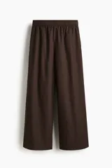 Pantalón de corte holgado en algodón, con piernas amplias y largo tobillero. Presenta tiro alto, cintura elástica y bolsillos laterales discretos.