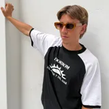 Lentes de sol con armazón de acetato en tono ámbar traslúcido y cristales degradados. Presentan un diseño de marco cuadrado con patillas gruesas y detalle metálico en la unión.