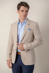 Saco de lino corte slim fit, color beige, con solapa de muesca, cierre frontal de dos botones y bolsillos con solapa.