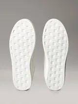 Zapatillas de ante Calvin Klein de color blanco, con detalles en contraste negro en el talón e inserciones de ante en la puntera. Cuentan con cordones blancos, suela de goma y el monograma de la marca en el lateral y la lengüeta.
