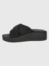 Sandalias plataforma Hush Puppies modelo Gise de cuero color negro, con diseño de tiras cruzadas texturizadas y detalle de hebilla circular metálica plateada.