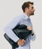 Mochila masculina de estilo business color negro, de material sintético con cierre de cremallera y bolsillo frontal.