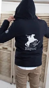 Campera parka azul marino con capucha, cierre frontal con cremallera y broches a presión, bolsillos laterales con solapa y puños ajustables con broches. Estampado en la espalda con un jinete a caballo y la inscripción "Bagual".