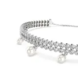 Pulsera plateada con doble hilera de cristales Swarovski y perlas colgantes. Cierre ajustable con bola deslizante.