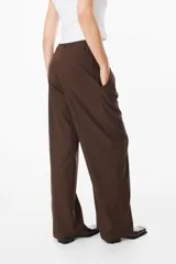 Pantalón sastrero de corte recto y fit relajado, con cintura alta, cierre frontal con botón y bolsillos laterales. Presenta una caída fluida y elegante.