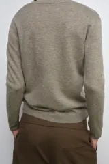 Chaqueta tipo cárdigan de lana, color beige, con escote en pico, manga larga y cierre frontal con botones.