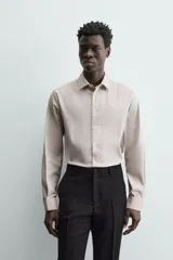 Camisa de hombre color beige claro, de corte slim fit, con cuello italiano, manga larga y cierre frontal de botonadura.