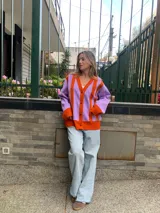 Cárdigan tejido de lana merino color lila con rayas verticales color naranja.