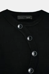 Chaqueta de punto de manga larga con cuello redondo y cierre frontal asimétrico con botones.