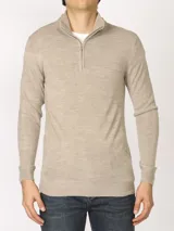 Sweater verde oliva de tejido acrílico con textura similar al cashmere, corte clásico, cuello alto con cierre metálico y tirador de cuerina ecológica.