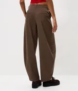 Pantalón de sastrería modelo barrel, color marrón, con tiro medio, cintura con pasantes, cierre frontal, bolsillos posteriores embutidos y recortes frontales estructurados.