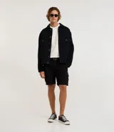 Bermuda cargo de sarga color negro, con cintura tradicional, bolsillos laterales útiles y cierre de cremallera con botón.