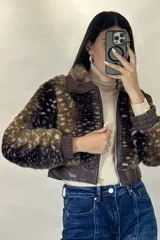 Campera corta de piel sintética con estampado animal print tipo ciervo, cuello clásico, cierre frontal y puños elásticos en cuero sintético.