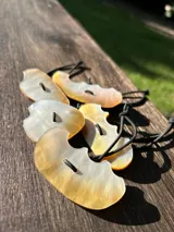 Goma de pelo con elegante pieza decorativa de nácar de forma ovalada, diseñada para aportar un toque sofisticado y único al peinado.