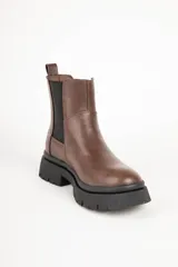 Bota Chelsea marrón de símil cuero con elásticos laterales negros y suela track negra.