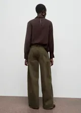 Pantalón de jean estilo barrel de tiro bajo, con diseño de cinco bolsillos, cierre frontal de cremallera y botón, y trabillas para cinturón.