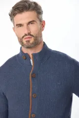 Cardigan de punto grueso color azul marino, con cuello alto, cierre frontal de botones y ribetes en contraste color marrón.