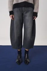 Pantalón jean de tiro medio y silueta amplia estilo balloon, confeccionado en algodón de color gris oscuro con efecto deslavado.