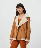 Campera marrón de terciopelo con cuello camisero y forro de sherpa color crema. Tiene cierre frontal con cremallera y bolsillos delanteros con cremallera.