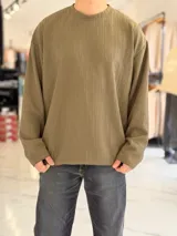 Buzo oversize de manga larga en color verde militar, con textura acanalada y cuello redondo.