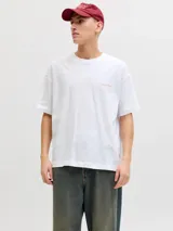 Remera blanca de manga corta, corte holgado y cuello redondo, con pequeño estampado en el pecho.