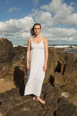 Vestido midi de broderie blanco, con breteles finos, escote redondo y corte holgado. Cuenta con forro interior de voile.