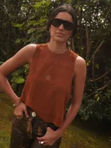 Chaleco de gamuza negro, sin mangas, con cuello redondo y diseño bordado de un sol en el pecho.