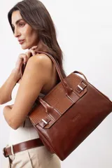 Cartera de mano estructurada de cuero vacuno rojo, con doble asa superior y detalles de charol en la parte superior. Cuenta con cierres metálicos y apliques decorativos laterales con hebillas.