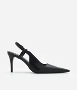 Zapato tipo slingback de color negro, confeccionado en poliuretano con acabado liso. Presenta una punta fina alargada, tacón fino y tira trasera con elástico para ajuste.