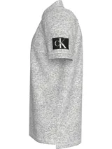 Chomba gris jaspeado de piqué de algodón peinado, con cuello clásico y tapeta de dos botones. Tiene mangas cortas, dobladillo con aberturas laterales y logo de Calvin Klein en la manga.