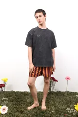 Remera gris de algodón con efecto acid wash, cuello redondo y mangas cortas. Presenta un pequeño logo estampado en el pecho y un estampado más grande en la espalda.