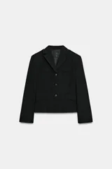 Blazer corto negro de cuello con solapa y manga larga, con hombreras, trabillas en los hombros, falsos bolsillos con solapa en el pecho y en la parte delantera, y cierre frontal con botones.
