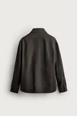 Sobrecamisa relaxed fit confeccionada en tejido de lino de color negro, con cuello solapa, manga larga con puño abotonado, bolsillos de plastrón en la cadera y cierre frontal de botones.