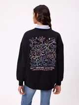 Sweater negro de corte holgado con estampado trasero de flores y el logo "Rusty" en colores neón.