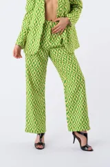 Pantalón de corte recto con estampado geométrico en tonos verde y amarillo, de tiro medio con cintura estructurada y cierre frontal.
