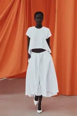 Camiseta blanca de algodón con cuello redondo, manga corta y diseño asimétrico de bajo redondeado y más largo en la espalda.