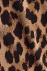 Vestido midi entallado de punto elástico con estampado de leopardo. Presenta un diseño asimétrico de un solo hombro con un bretel ancho y detalle de fruncido en la manga. Incluye tajos laterales en el ruedo.