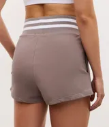 Bermuda deportiva de algodón color marrón topo, con cintura elástica ancha en contraste con rayas blancas y detalle de lettering bordado en el ruedo.