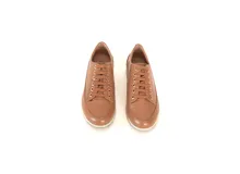 Championes de cuero color caramelo con diseño de textura tipo reptil en la parte superior y cordones al tono. Cuentan con suela plana de goma blanca y forro interior de cuero.