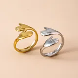 Set de dos anillos unisex, uno dorado y otro plateado, con diseño de manos abrazándose.
