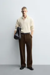 Pantalón de corte wide fit confeccionado en pana de algodón color marrón oscuro. Presenta bolsillos frontales, bolsillos traseros de vivo con botón y cierre frontal con cremallera y botón.