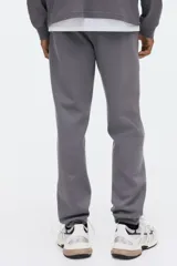 Pantalón deportivo de corte regular, confeccionado en tejido de felpa interlock con interior cepillado. Presenta cintura elástica con cordón de ajuste oculto, bolsillos laterales al bies, un bolsillo trasero insertado y puños acanalados en los tobillos.