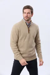 Buzo tejido de punto grueso en color azul marino, con cuello alto y cierre frontal parcial. Presenta detalles en gamuza en la zona del cierre y una textura en relieve en toda la prenda.