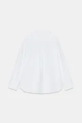 Camisa básica de algodón color celeste, con cuello solapa, escote en pico, manga larga y cierre frontal con botones.