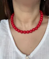 Collar corto de cuentas esféricas rojas con acabado brillante.